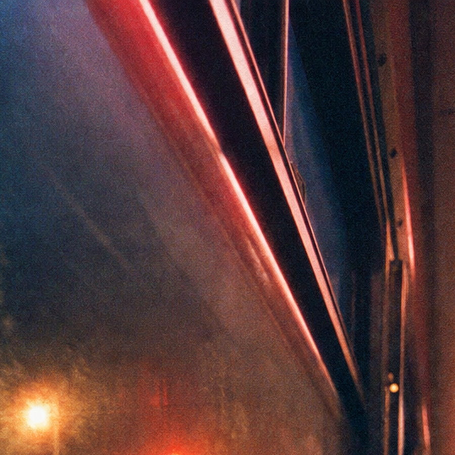 A 100% crop of fluorescent tubes on a night bus ceiling, each glowing with a soft red halo against cyan shadows